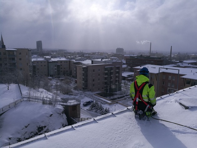 Kattotyön tekijä talvella katolla