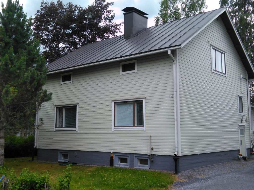 Omakotitalon tumma peltikatto maalattuna