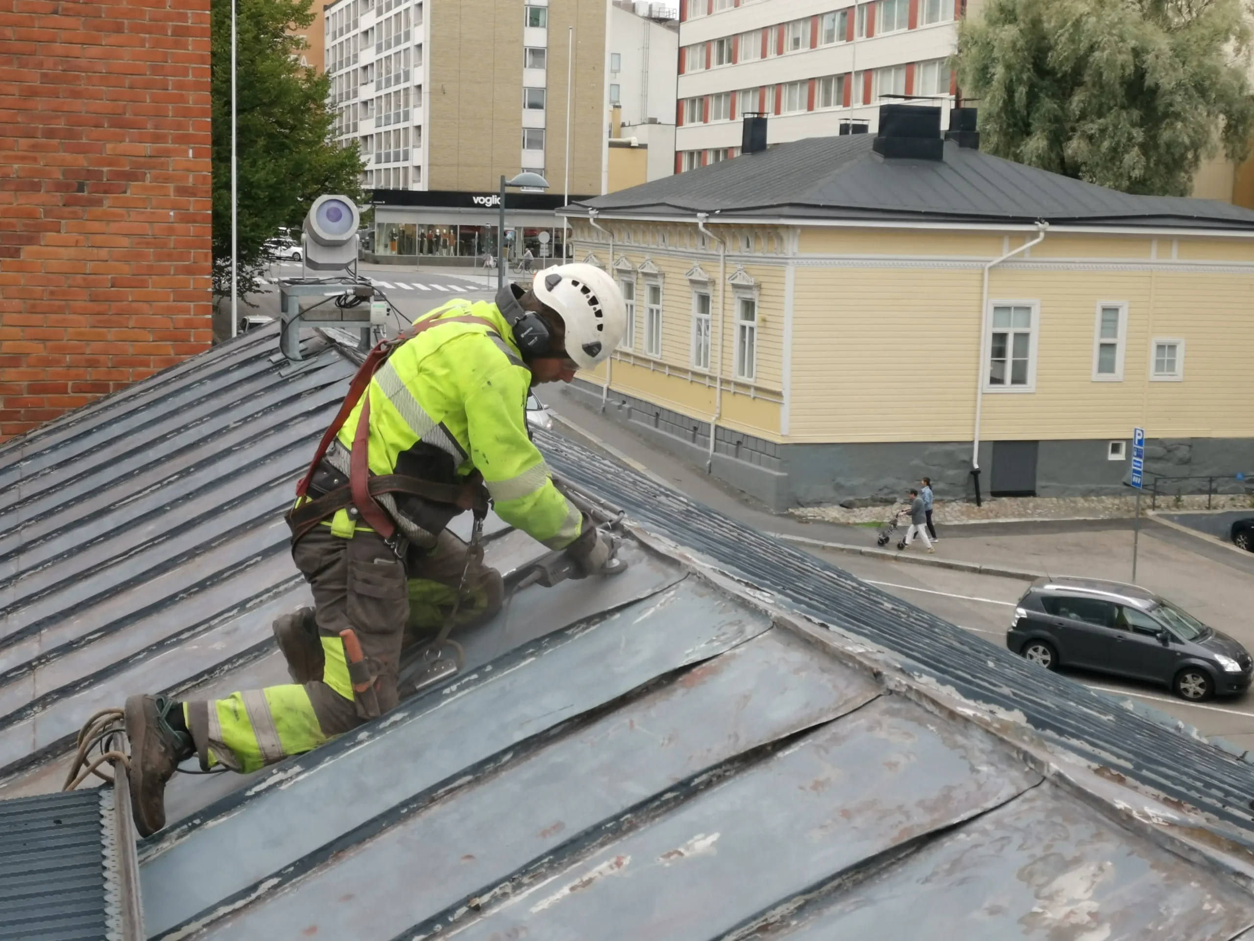 Kattomaalari hiomassa peltikattoa