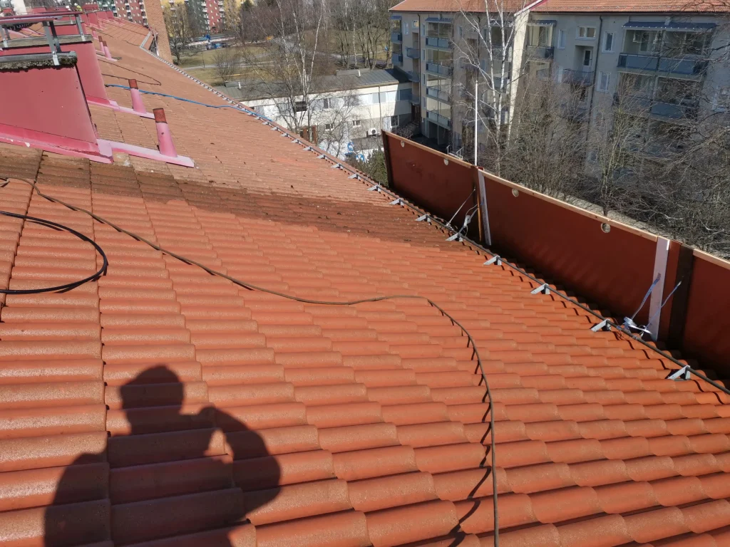 Tiilikaton pesu ja pinnoitus menossa katon reunat suojattuna